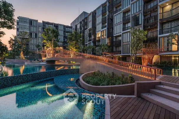 Luxurious modern apartment complex with stunning pool and landscaped gardens at sunset.