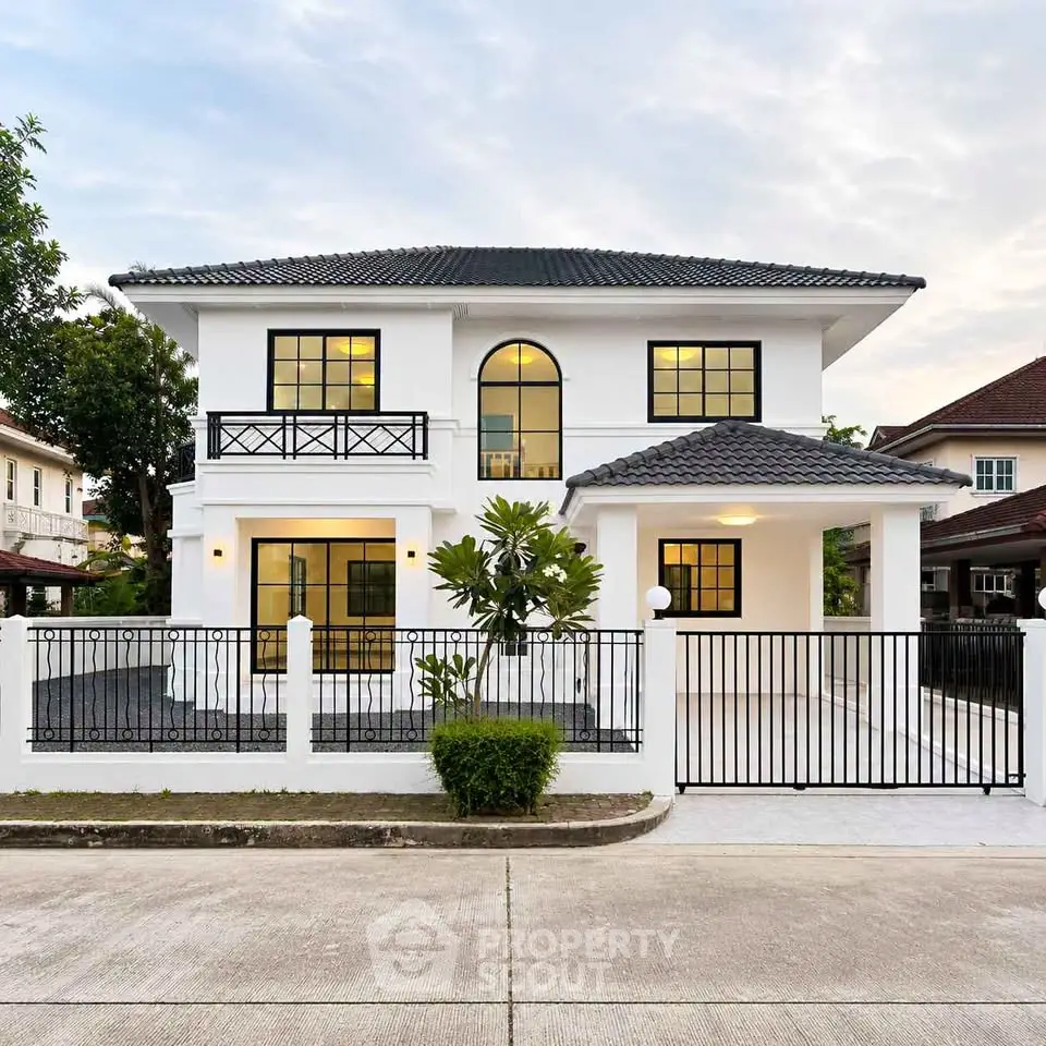 Elegant two-story white house with modern design and spacious driveway in a serene neighborhood.