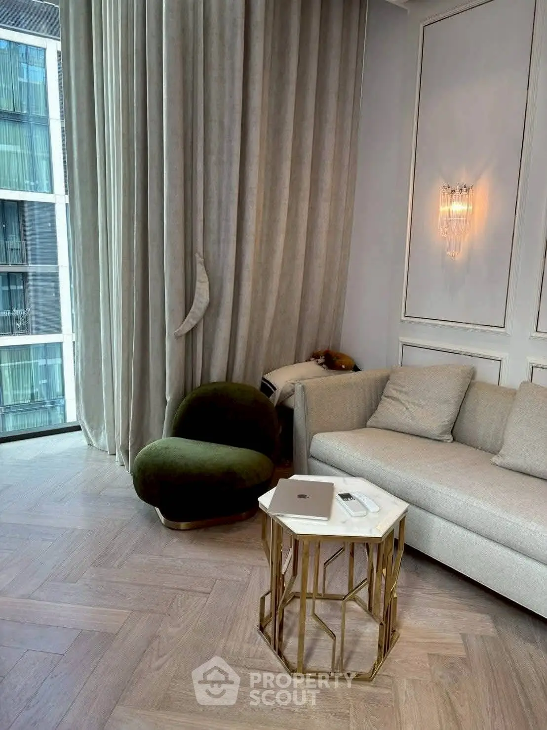 Luxurious living room with elegant decor, featuring a plush sofa, stylish armchair, and floor-to-ceiling windows.