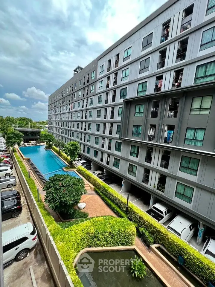 Modern apartment building with pool and lush greenery, offering urban living with serene outdoor amenities.
