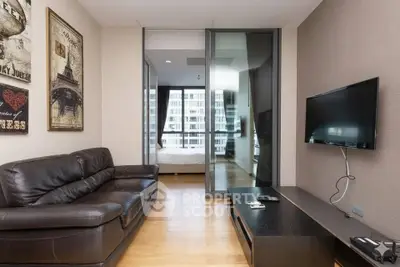 Modern living room with leather sofa and wall-mounted TV, leading to a bright bedroom with city view.