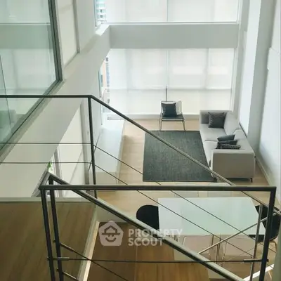 Modern open-plan living room with high ceilings and large windows.