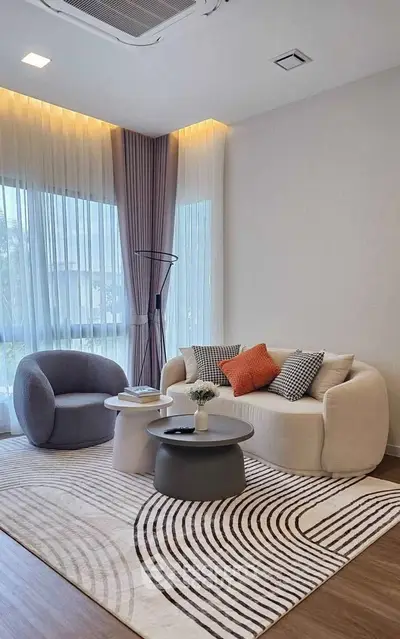 Modern living room with stylish furniture and large windows offering natural light.