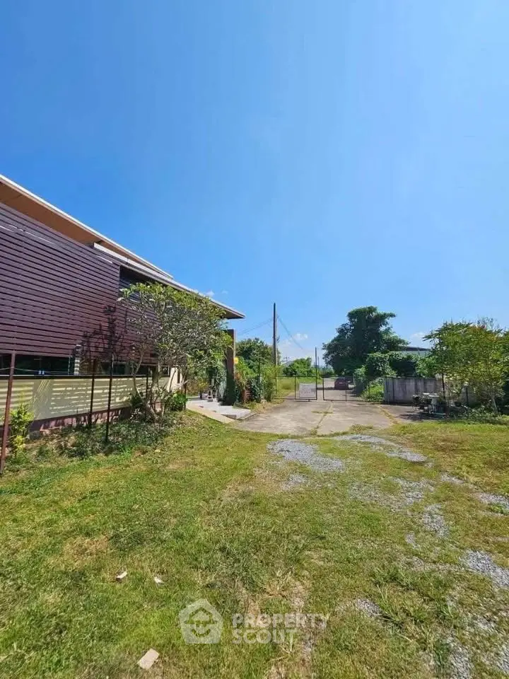 Charming suburban home with spacious yard and clear blue sky, perfect for family living.