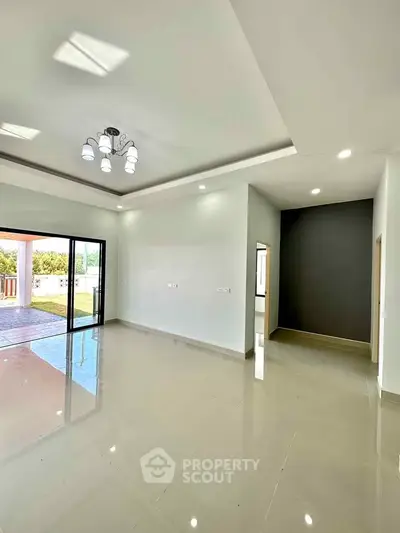 Spacious modern living room with large windows and elegant lighting, perfect for natural light and open living.