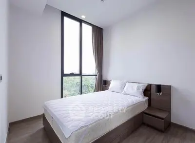 Modern bedroom with large window and minimalist design in a high-rise apartment.