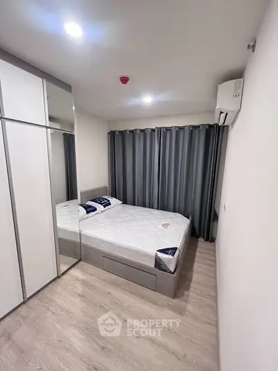 Modern bedroom with sleek design, featuring a comfortable bed and ample storage space.