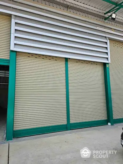 Spacious industrial warehouse with secure roller shutter doors and ample loading space.