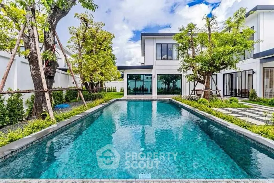 Luxurious modern home with stunning private pool and lush garden view.