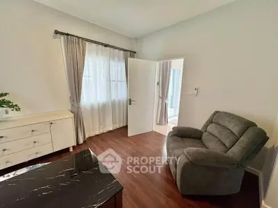 Cozy living room with armchair and elegant curtains, perfect for relaxation.