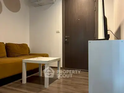 Cozy living room with modern sofa and sleek TV setup, perfect for relaxation.