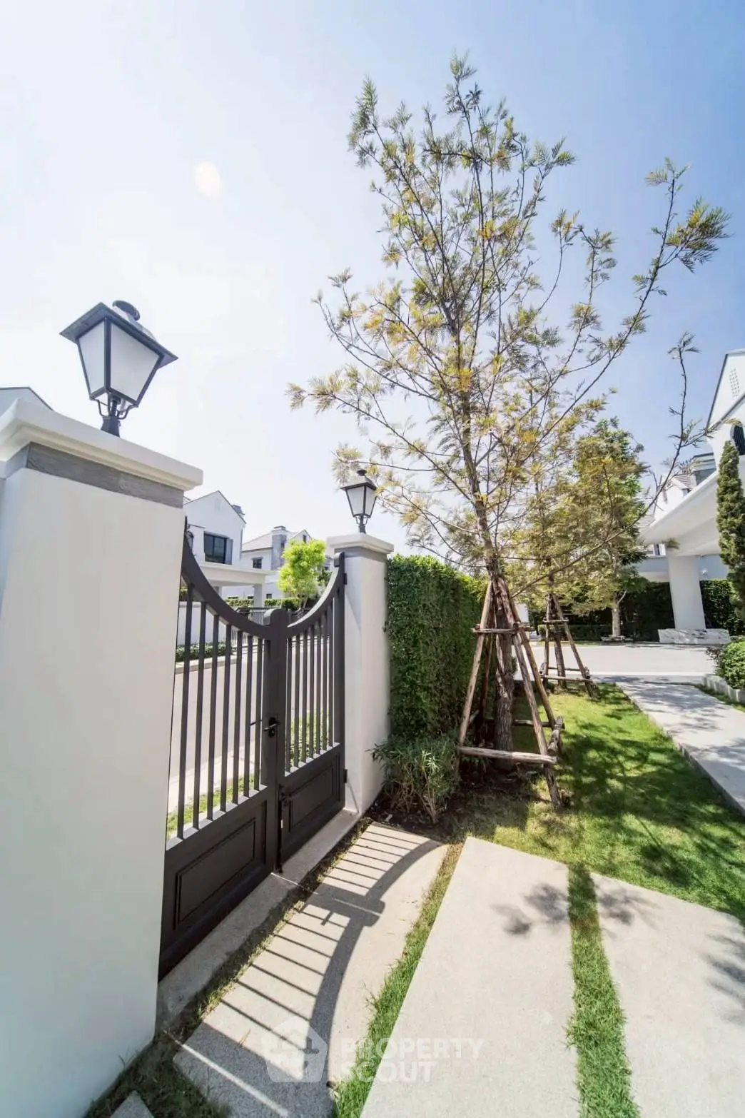 Elegant gated entrance with lush landscaping and modern architecture