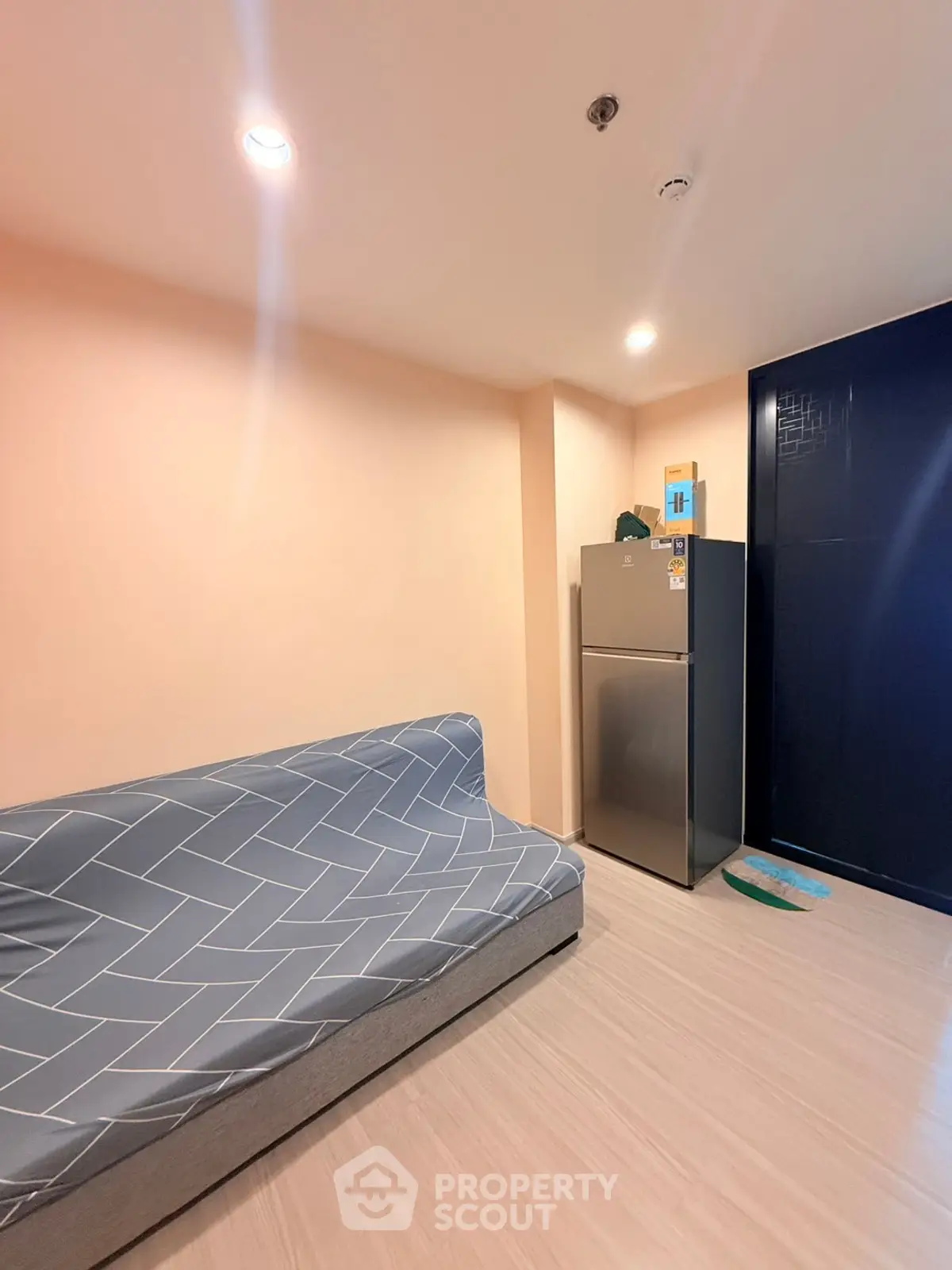 Cozy living room with modern fridge and stylish sofa in a contemporary apartment.