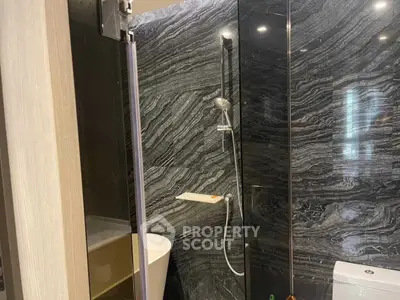 Luxurious modern bathroom with elegant marble walls and sleek fixtures.