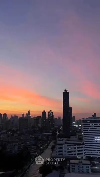 Stunning city skyline view at sunset with high-rise buildings and vibrant sky colors.