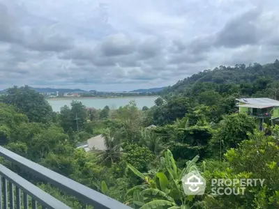 Stunning panoramic view from balcony overlooking lush greenery and serene water body.