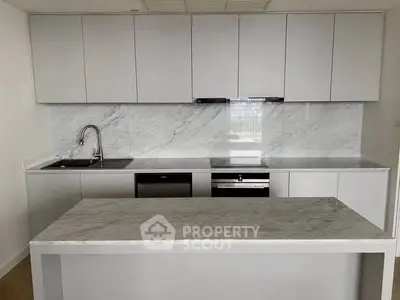 Modern kitchen with sleek cabinetry and marble countertops in a contemporary apartment.