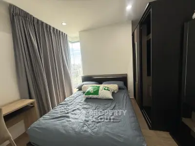 Modern bedroom with city view, featuring sleek furniture and floor-to-ceiling windows for natural light.