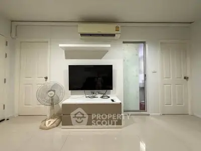 Modern living room with sleek TV setup and air conditioning, perfect for comfortable living.