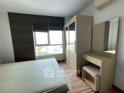 Modern bedroom with large window and stylish furniture in a high-rise apartment.