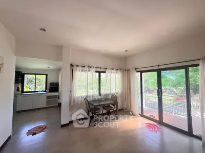 Spacious living room with large windows and balcony access, perfect for natural light and outdoor views.