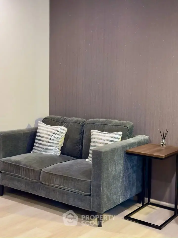 Cozy living room with plush sofa and modern side table, perfect for relaxation.