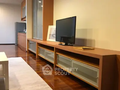 Modern living room with sleek wooden furniture and flat-screen TV, showcasing elegant interior design.