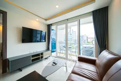 Modern living room with leather sofa and balcony view in a high-rise apartment.