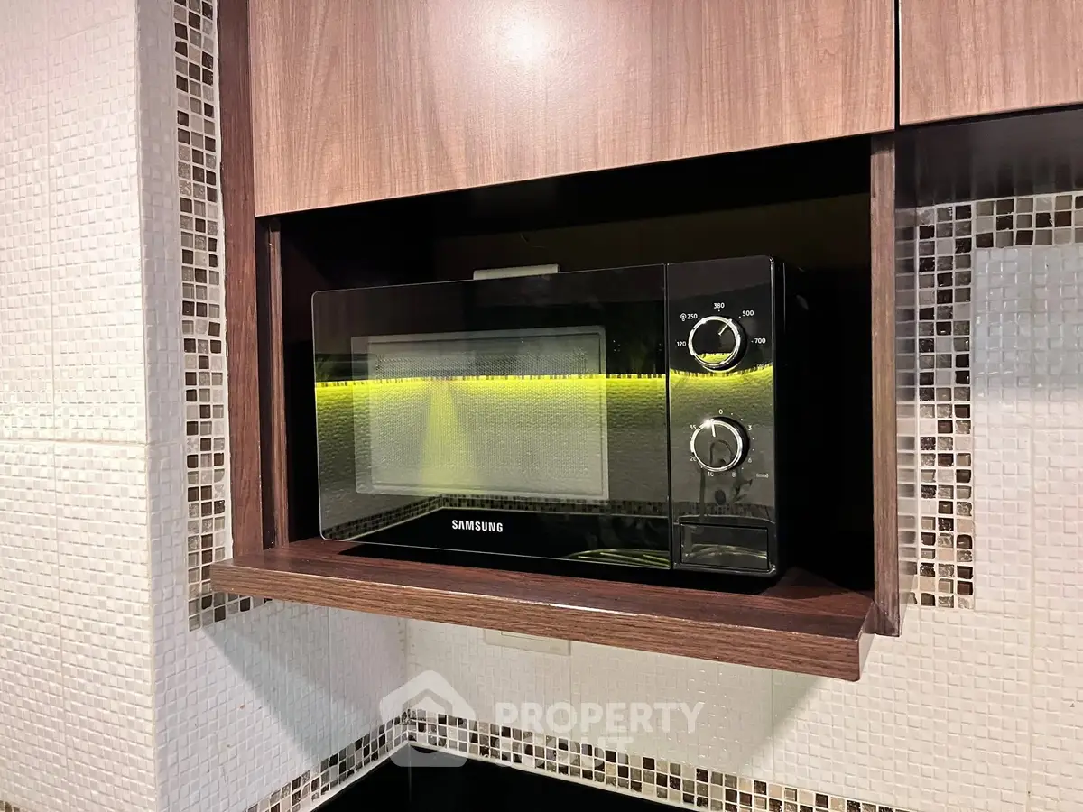 Modern kitchen with built-in microwave and stylish mosaic tiles