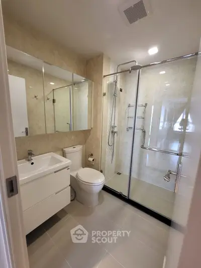 Modern bathroom with glass shower and sleek fixtures in a contemporary home.