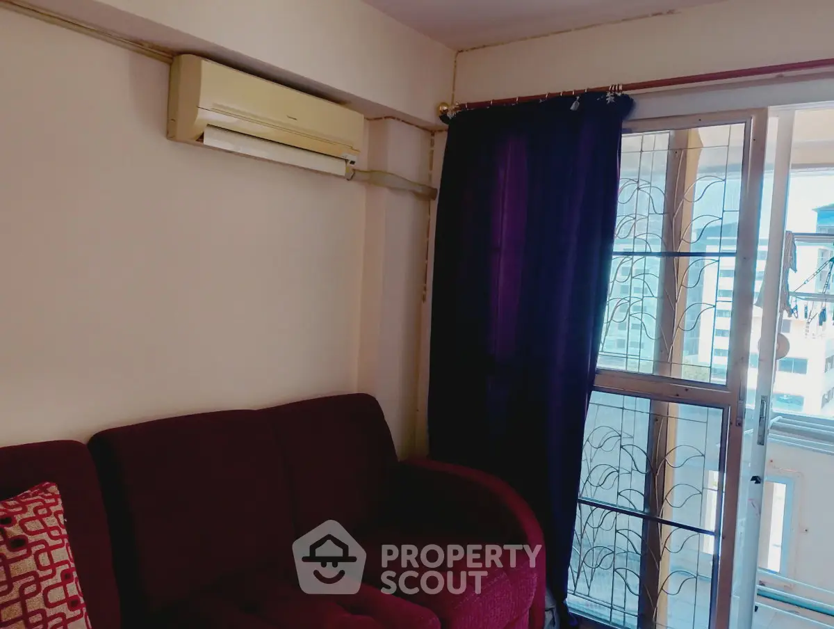 Cozy living room with air conditioning and balcony access, perfect for relaxation and comfort.