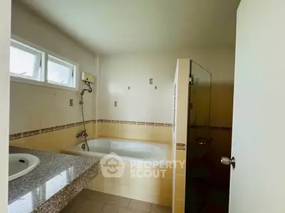 Spacious bathroom with bathtub and modern fixtures, ideal for relaxation.