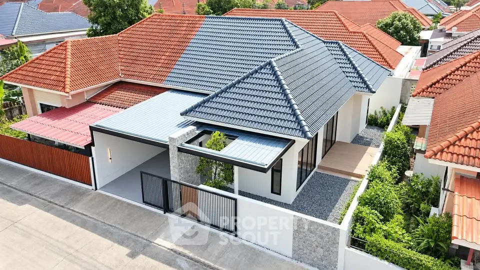 Modern single-story house with tiled roof and landscaped garden in a suburban neighborhood.