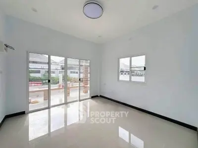 Spacious and bright room with large windows and sliding doors leading to outdoor area.