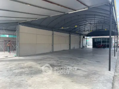 Spacious covered parking area with concrete flooring and metal roof structure