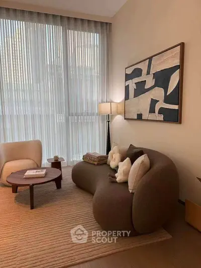 Stylish modern living room with cozy furniture and abstract art, perfect for relaxation and entertaining.