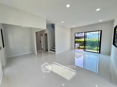 Spacious modern living room with large windows and glossy white tiles