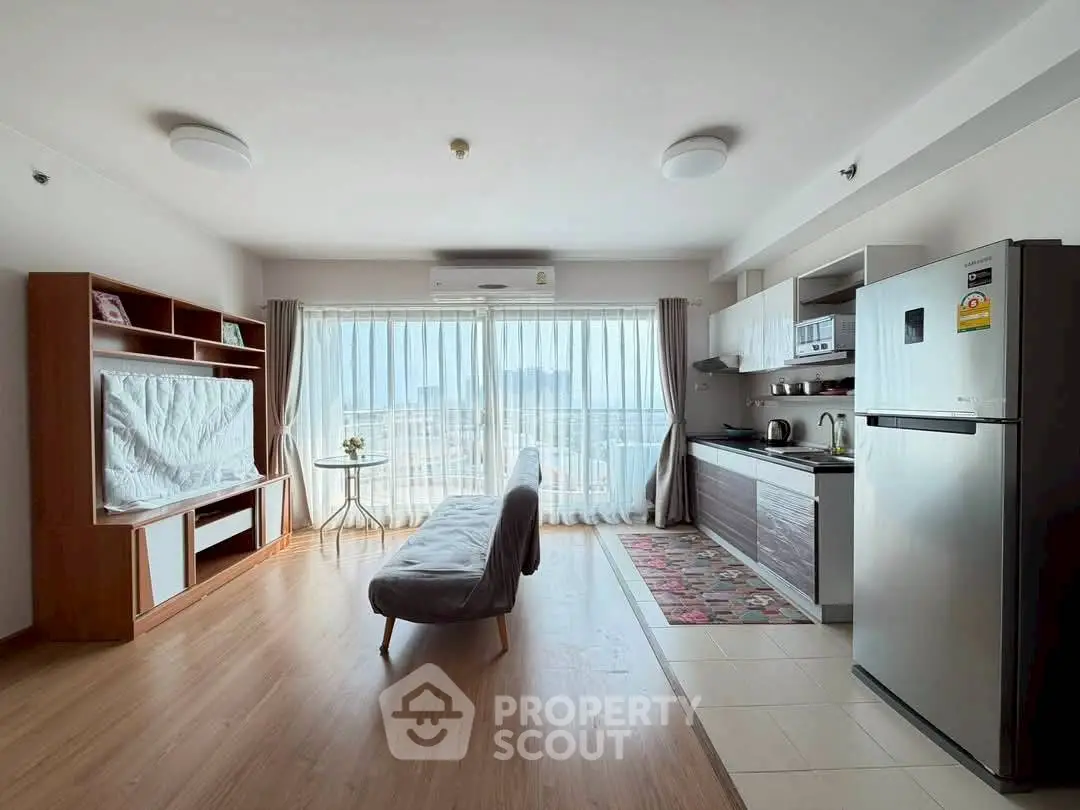 Spacious open-plan living room with modern kitchen and stunning city view.