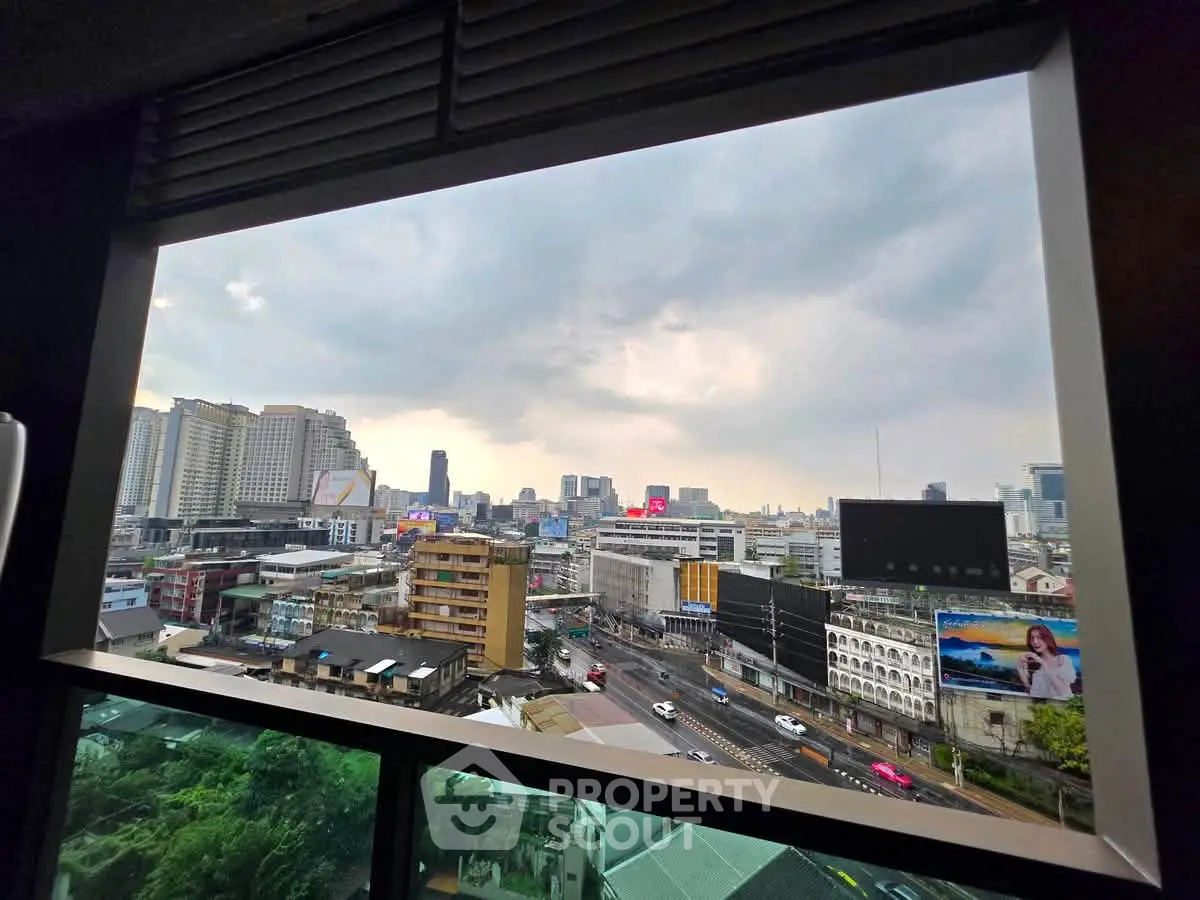 Stunning cityscape view from a high-rise building window, showcasing urban skyline and bustling streets.