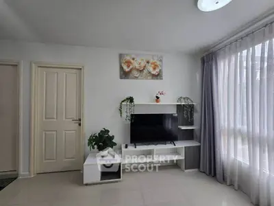 Modern living room with TV unit, elegant decor, and large window with curtains.