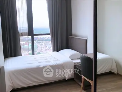 Modern bedroom with large window offering stunning city view, featuring sleek furniture and elegant decor.