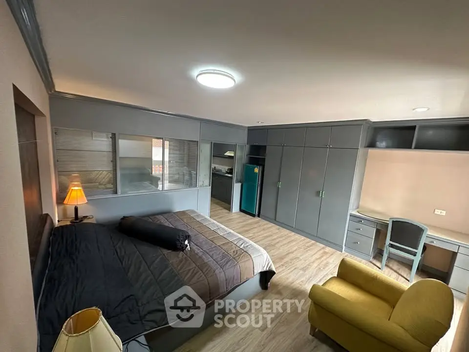 Spacious bedroom with modern furnishings and cozy seating area