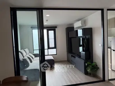 Modern living room with sleek furniture and large window, perfect for relaxation.