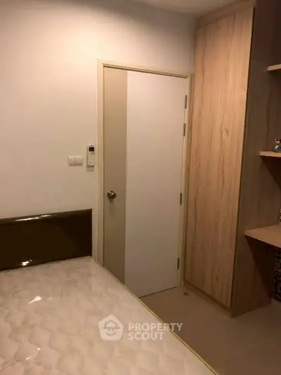 Cozy bedroom with modern wooden wardrobe and comfortable bed.