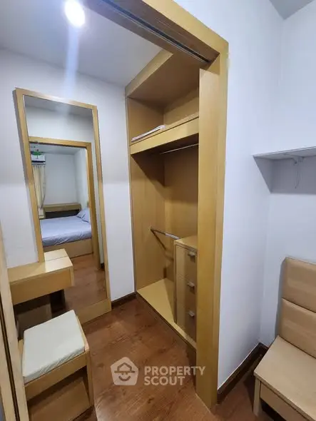 Spacious walk-in closet with wooden finishes and adjacent bedroom view.