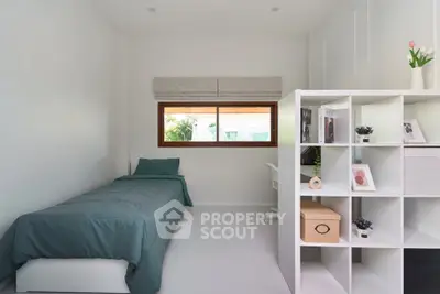 Modern minimalist bedroom with single bed and stylish storage unit.