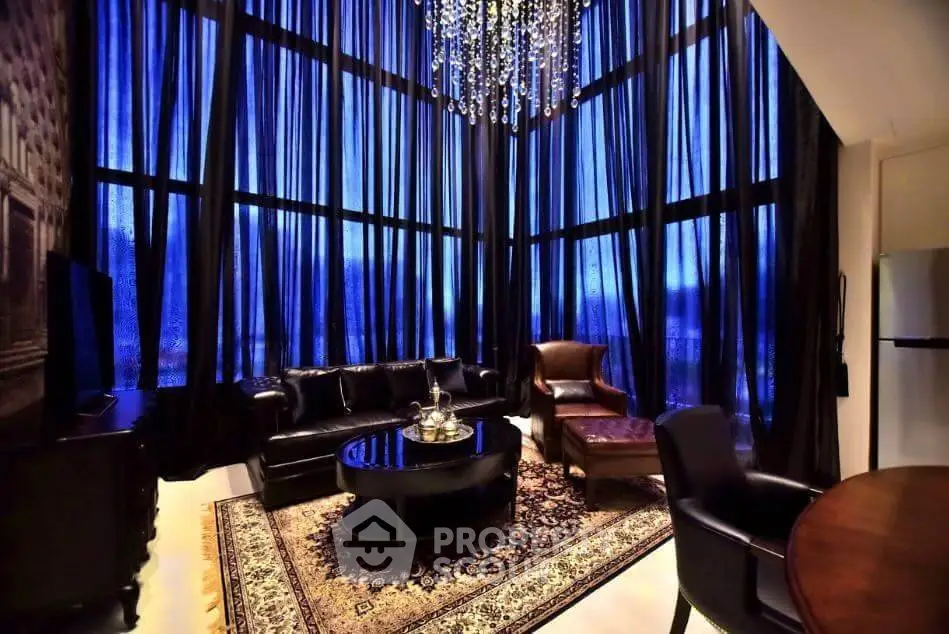 Luxurious living room with high ceilings, elegant chandelier, and floor-to-ceiling windows.