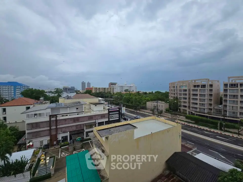 Stunning cityscape view from a high-rise building showcasing urban architecture and lush greenery.