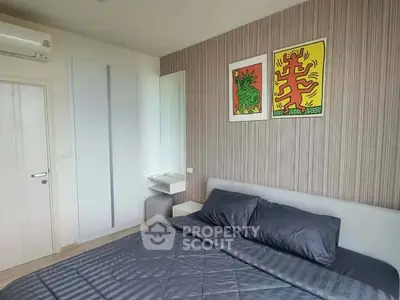 Modern bedroom with stylish decor and cozy bedding in a contemporary apartment.