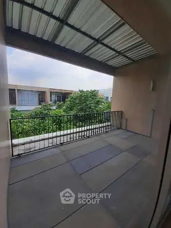 Spacious balcony with modern railing and garden view in luxury apartment.